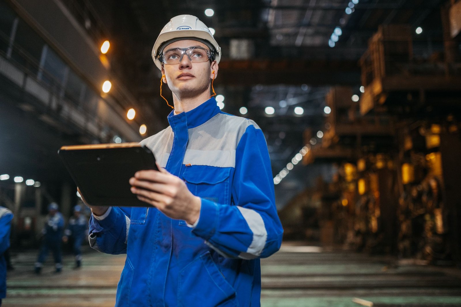 Industrie 4.0 Beratung: Ingenieur nutzt ein Tablet in einer modernen Produktionsanlage